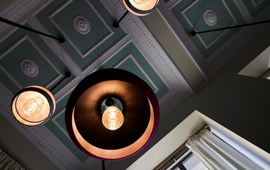 Tiger Loop Bar ceiling with ornate plaster details and vintage pendant lights at ON Residence
